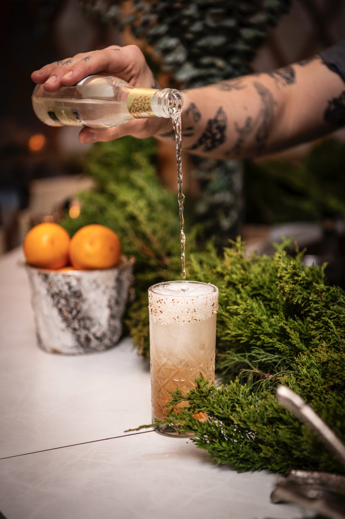 A seasonal cocktail being prepared at The Well’s holiday pop-up lounge in Toronto, with fresh ingredients and garnishes.